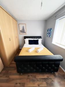 バーミンガムにある2 Bedroom Tudor House Pristine and Comfortable Close to Birmingham City Hospitalのベッドルーム1室(スリッパ2枚付)