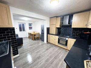 a kitchen with wooden floors and a table in it at 2 Bedroom Tudor House Pristine and Comfortable Close to Birmingham City Hospital in Birmingham