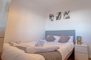 スラウにあるDeluxe 2 Bed Apartment- Near Heathrow, Legoland, Windsor Sloughのベッドルーム1室(ベッド2台、タオル付)