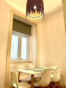 里斯本的住宿－時尚希亞多斯斯公寓，一间带桌椅和吊灯的用餐室