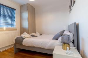 a bedroom with a bed and a window at Deluxe 2 Bed Apartment- Near Heathrow, Legoland, Windsor Slough in Slough