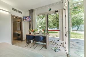 a bedroom with a desk and two blue chairs at Seven Park Hotel Lake Como - Adults Only in Colico