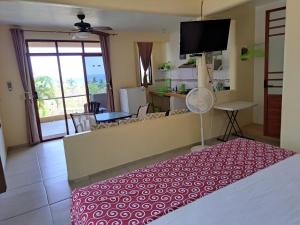 a room with a bed and a living room with a kitchen at Posada Nautica in Mazunte