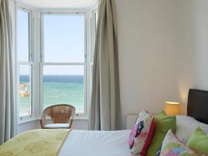 - une chambre avec un lit et une fenêtre donnant sur l'océan dans l'établissement Waves End, à St Ives
