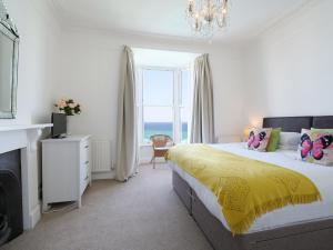- une chambre avec un lit et une grande fenêtre dans l'établissement Waves End, à St Ives