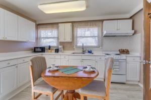 uma cozinha com uma mesa e cadeiras de madeira e um lavatório em Aurora Horse Farm Apartment Near Denver! em Aurora