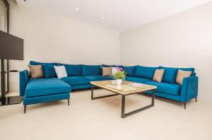- un canapé bleu et une table basse dans le salon dans l'établissement Casa MD, à Benitachell