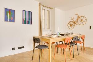 una mesa de comedor con sillas y una bicicleta en la pared en PorteMaillot & La Défense 4 Bedroom 10 people en Neuilly-sur-Seine