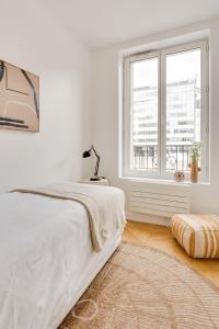 Habitación blanca con cama y ventana en PorteMaillot & La Défense 4 Bedroom 10 people en Neuilly-sur-Seine