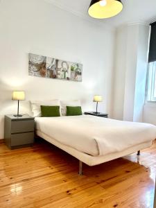 a bedroom with a large white bed with two lamps at Fashion Chiado - SSs Apartments in Lisbon