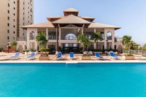 basen z niebieskimi krzesłami i budynek w obiekcie Luxurious 2BDR with Ocean View w mieście Santo Domingo