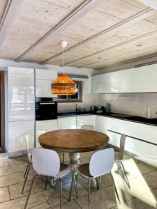 a kitchen with a table and chairs in a room at Mon Raccard Cosy - 4 vallées in Bruson