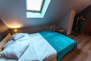 um quarto com uma cama branca e um cobertor azul em Rosa em Karpacz