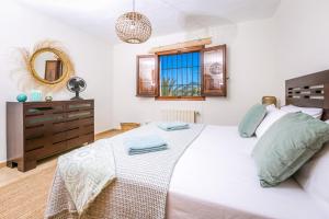 a bedroom with a large white bed and a dresser at Casa Toscana in Jávea +37 photos