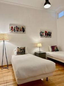 里斯本的住宿－時尚希亞多斯斯公寓，白色的客房配有两张床和一盏灯