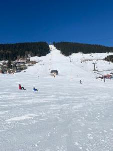 a group of people skiing down a snow covered slope at Ferienwohnung Keilbergblick in Kurort Oberwiesenthal