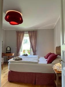 a bedroom with a large bed with a red light at VILLA FELICE_UNESCO ALPS AREA in Verzuolo