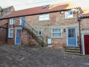 a brick house with blue doors and a staircase at Spring Rose in Bedale