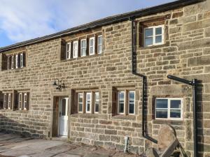 an old brick building with a white door at The Farmhouse in Keighley