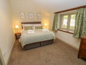 a bedroom with a bed with two towels on it at The Farmhouse in Keighley
