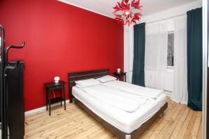 a bedroom with a red wall and a bed at Perfect Long-term Stay Stylish and Spacious Top Center Next to Vitosha Blvd in Sofia