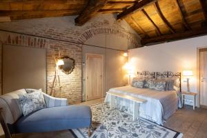 1 dormitorio con cama y pared de ladrillo en Antica Corte Pallavicina Relais en Polesine Parmense