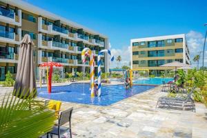 une piscine avec un hôtel en arrière-plan dans l'établissement Studio Deluxe Térreo Porto de Galinhas Mana Beach 350m do mar, à Porto de Galinhas