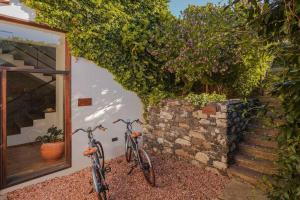 zwei Fahrräder, die neben einer Mauer mit Blumen geparkt sind in der Unterkunft Botanica Living Magnolia Apt in Quinta Grande