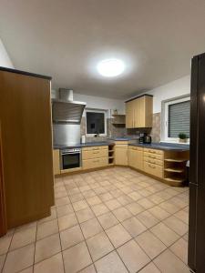 a large kitchen with wooden cabinets and a tile floor at Rheinview Urbar Haus in Urbar