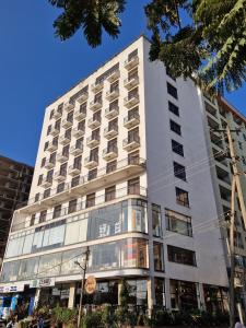 a tall white building with many windows at Zemilo Hotel Apartment in Addis Ababa