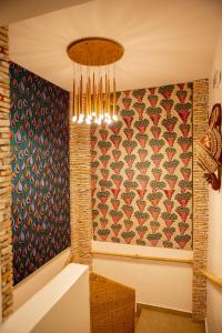 uma sala de jantar com uma parede estampada em Le Karé Ébène em Cotonou