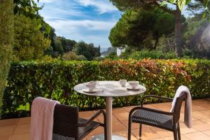 a table and chairs with cups and saucers on a patio at Albamar Apartaments in Lloret de Mar