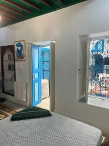 ein Schlafzimmer mit einem Bett und einer blauen Tür in der Unterkunft La maison 4 puits in Sidi Bou Saïd