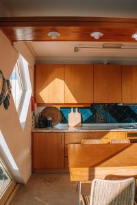 a kitchen with wooden cabinets and a wooden table at Just Like Home - AP da Costa in Caminha