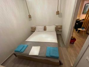 a bed in a small room with blue towels on it at Dukas Apartment in Limenas