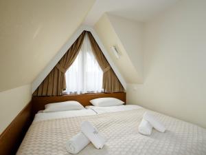 a bedroom with two beds with white pillows and a window at Pensjonat Dziubas - 5 minut na piechotę do stacji narciarskiej Kotelnica i term Bania, parking przy obiekcie in Białka Tatrzańska