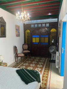a bedroom with a bed and a chandelier at La maison 4 puits in Sidi Bou Saïd