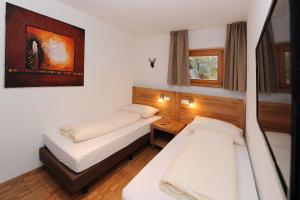 ein Schlafzimmer mit 2 Betten und einem Bild an der Wand in der Unterkunft Kleiner Turm 1 in Schruns-Tschagguns