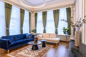 een woonkamer met een blauwe bank en een tafel bij Grand Hotel Residents in Tartu