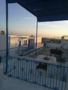 einen Balkon mit einem Tisch auf einem Gebäude in der Unterkunft La maison 4 puits in Sidi Bou Saïd