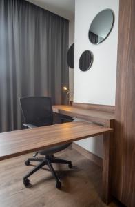 ein Büro mit einem Schreibtisch mit einem Stuhl und einem Spiegel in der Unterkunft Sheraton Guadalajara Expo in Guadalajara