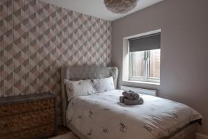 un osito de peluche sentado en una cama en un dormitorio en Quirky, Vintage 2 bed flat, en Londres