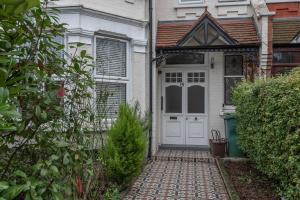 a white front door of a white house at Quirky, Vintage 2 bed flat in London