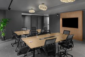 a conference room with tables and chairs and a flat screen tv at Aloft New York Chelsea in New York