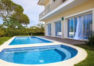 an image of a swimming pool in front of a house at Luxury Villa Iberosta - 4BDR, Private Beach, Pool & Jacuzzi in Punta Cana