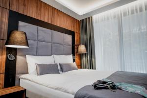 a bedroom with a large bed with a large headboard at Bursztynowe Resort&SPA Stegna in Stegna