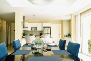 uma sala de jantar com uma mesa de vidro e cadeiras azuis em Luxury Villa Iberosta - 4BDR, Private Beach, Pool & Jacuzzi em Punta Cana