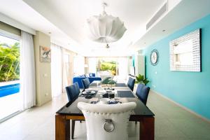uma sala de jantar com uma mesa e paredes azuis em Luxury Villa Iberosta - 4BDR, Private Beach, Pool & Jacuzzi em Punta Cana