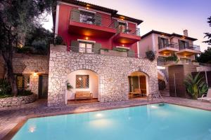 a villa with a swimming pool in front of a house at Diodati Villas in Nikiana