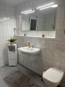Ferienwohnung Wohlfühloase في Oberrimsingen: حمام مع حوض ومرحاض ومرآة